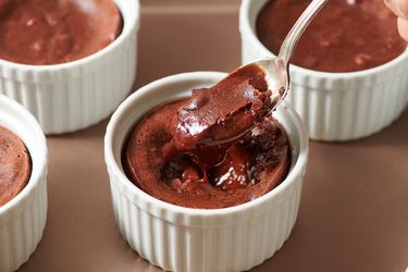 Chocolate lava cake in ramekin, not yet opened up with a spoon