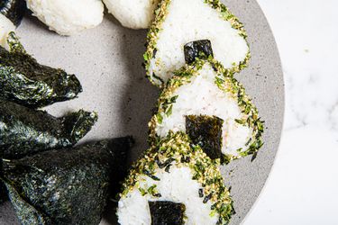 Overhead view of onigiri on a stone platter