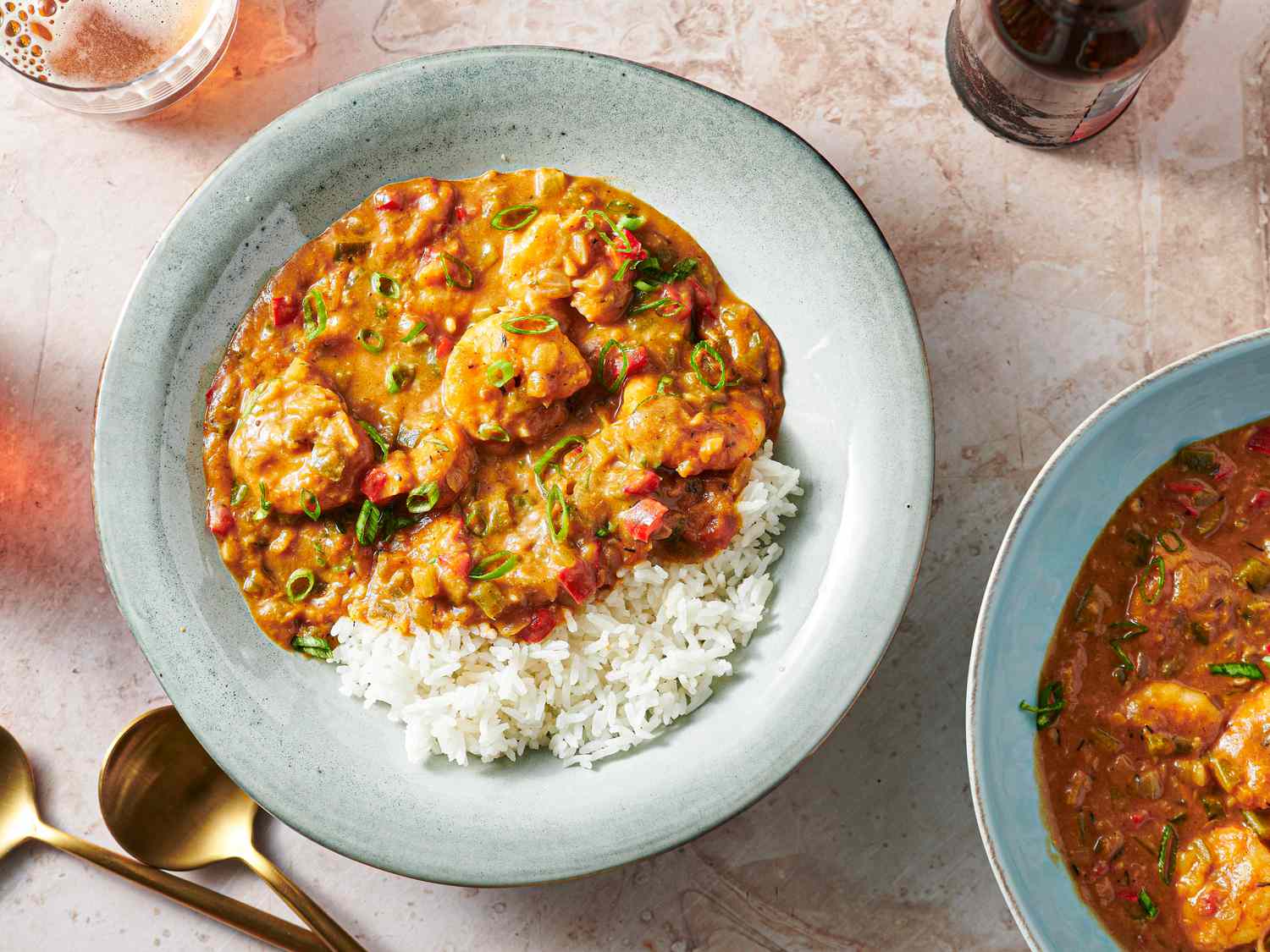 Shrimp étouffée in a soup plate with rice and thinly sliced scallions.