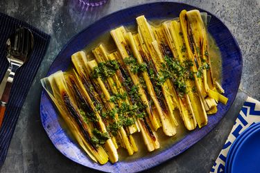 Overhead view of finished leeks plated on a blue platter