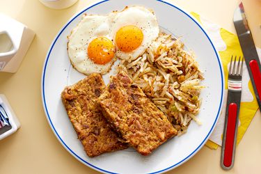 Overhead view of scrapple on a plate with eggs and hashbrowns