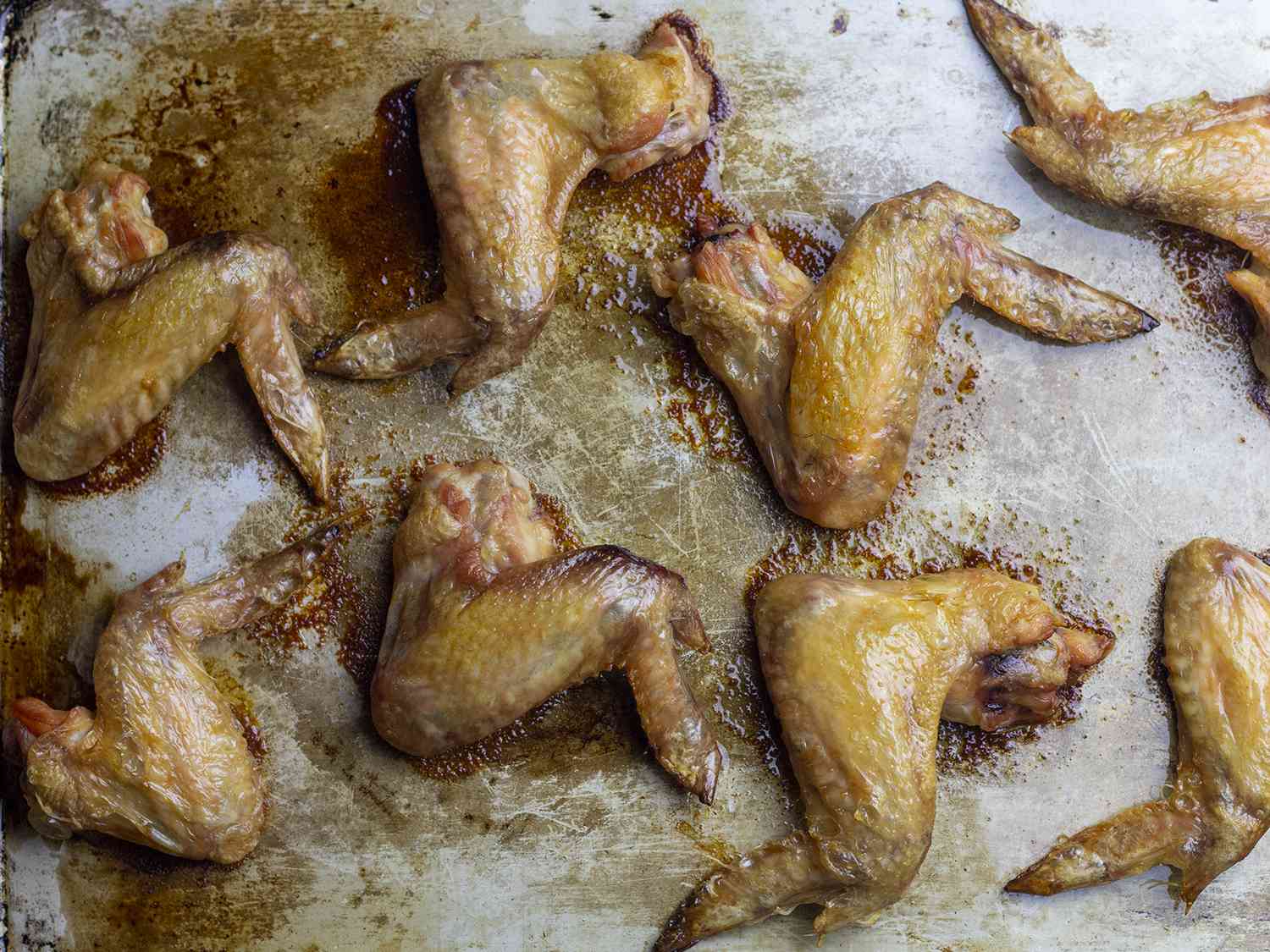 Chicken wings on an unlined rimmed baking sheet.