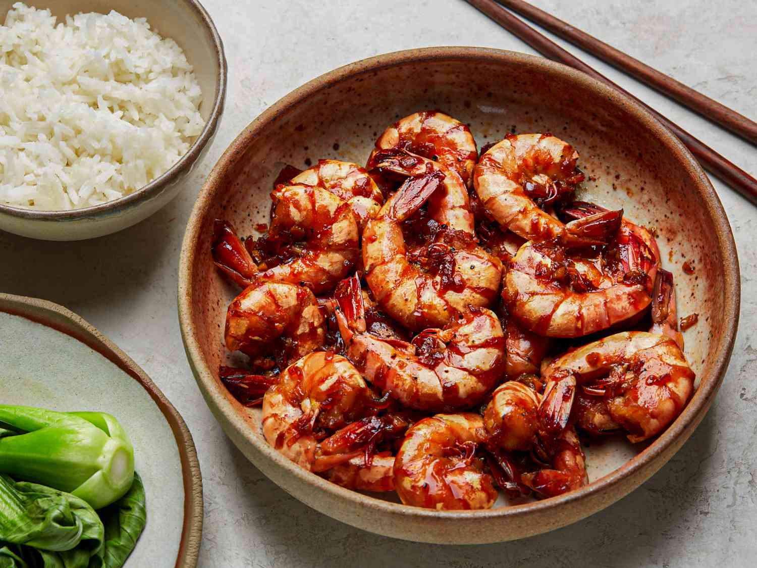 Overhead view of braised shrimp with a side of rice and bok choy.