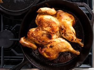 a whole chicken in a cast iron skillet on a stovetop