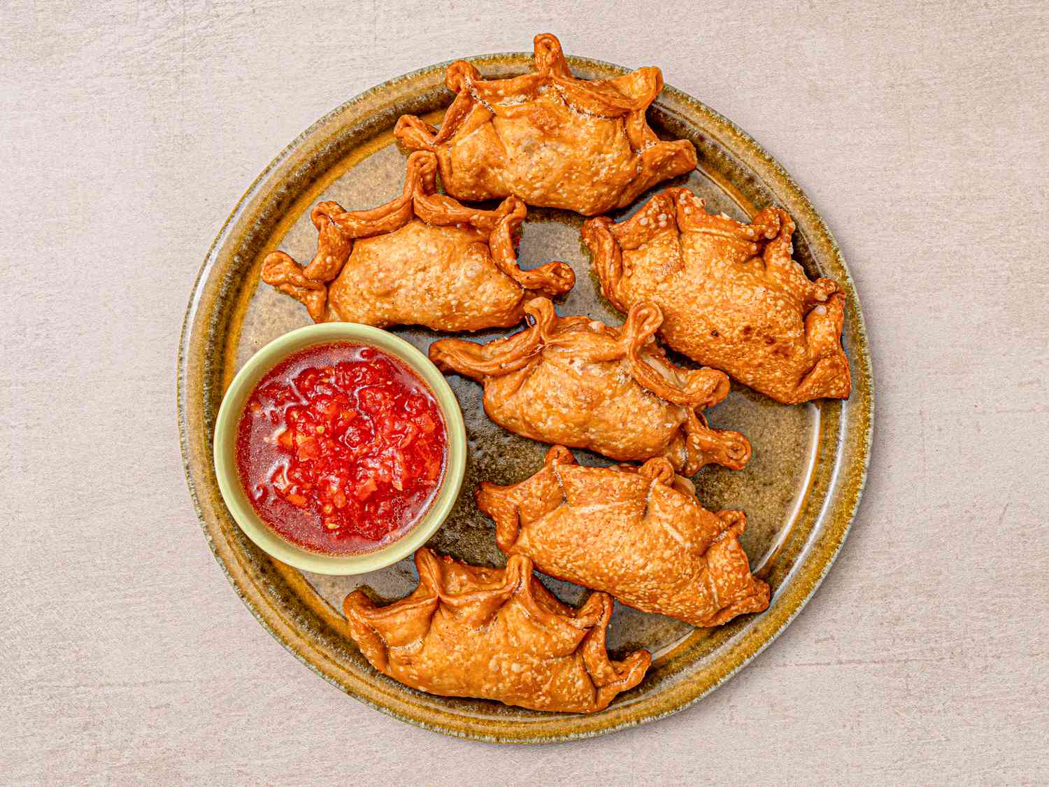 Overhead view of finished empanadas on a plate with dipping sauce