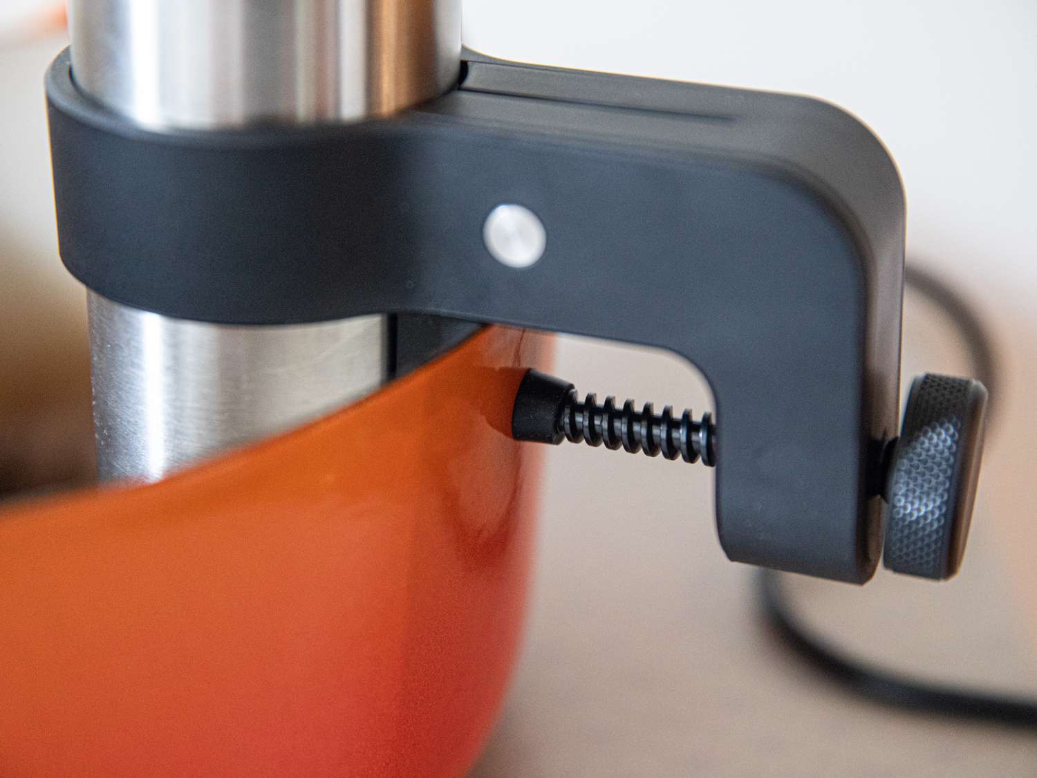 the anova precision cooker attached to an orange dutch oven