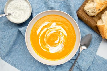 Carrot soup spooned into a white bowl.