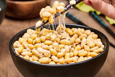 Side angle view of natto being picked up with chopsticks