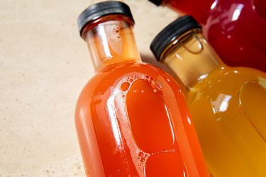 Overhead view of bubbles in three kombucha bottles