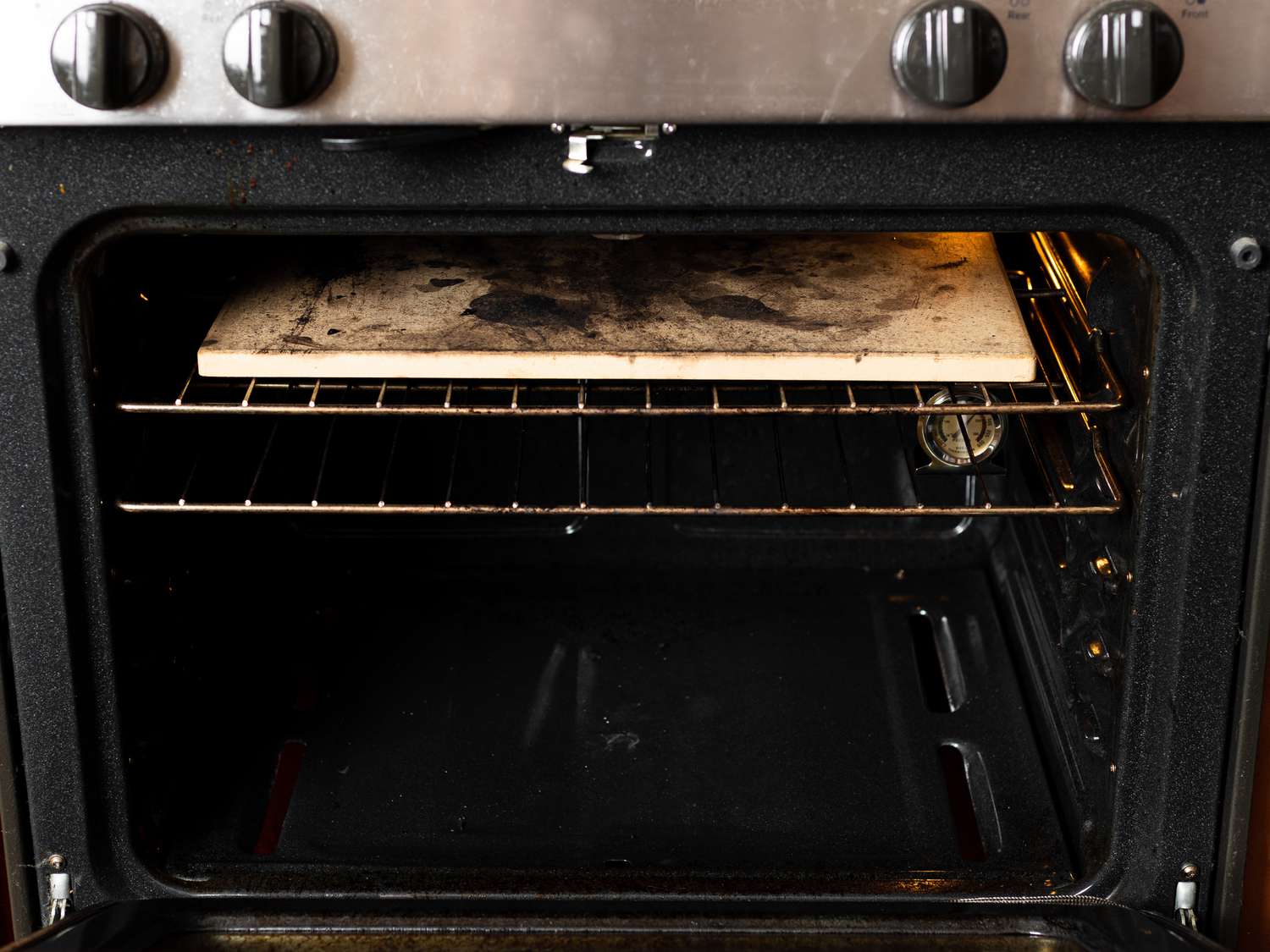 Oven rack with pizza stone in top position with a second rack placed one position below it