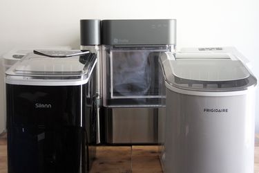 three winning ice makers on a wooden countertop with a white wall behind them.