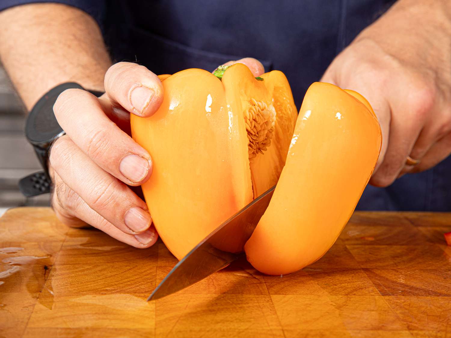 Side view of cutting one lob off a bell pepper