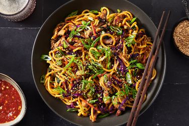 Stir-fried lo mein noodles with pork and vegetables served on a platter