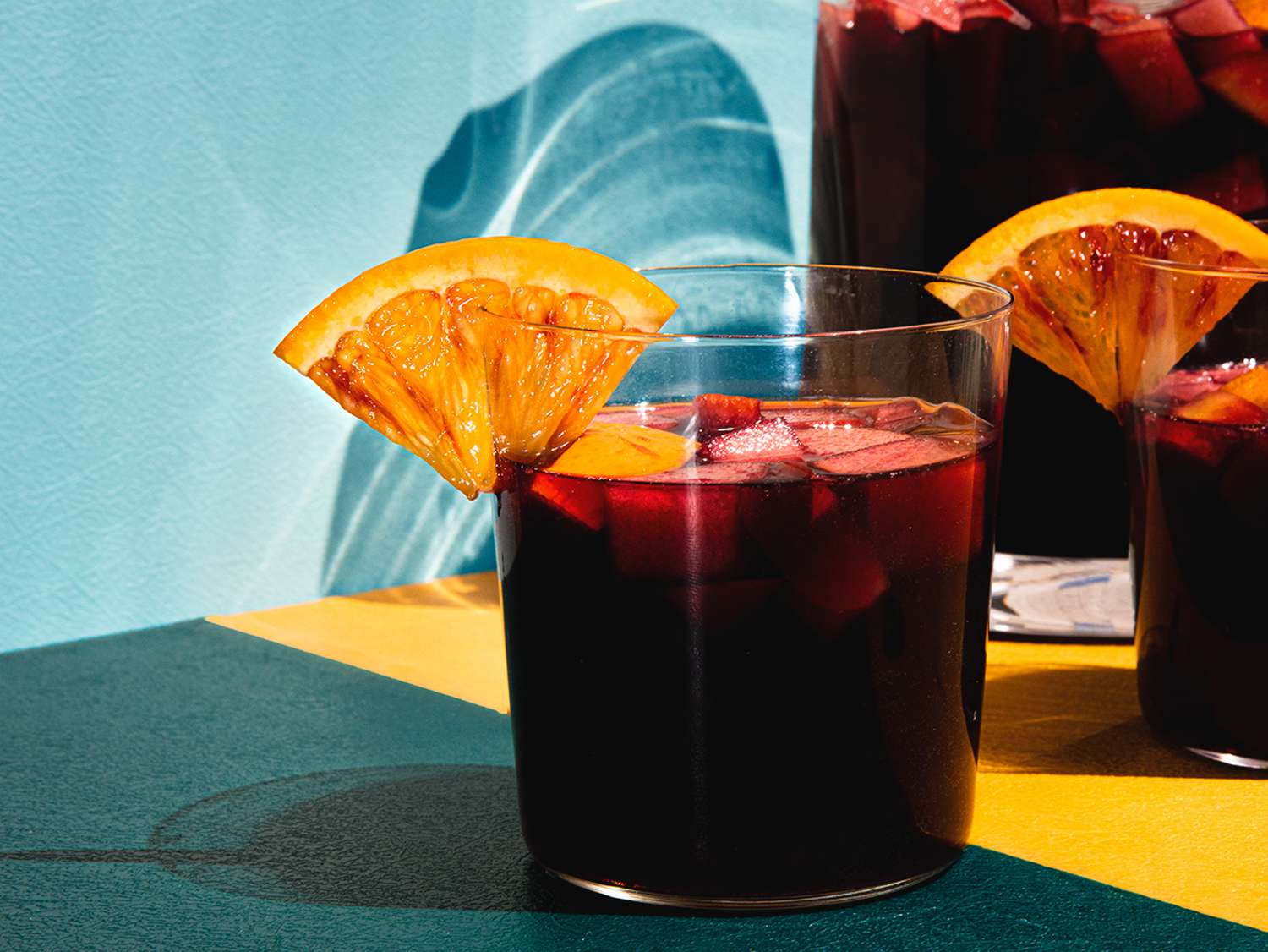 A glass of sangria adorned with an orange wedge.