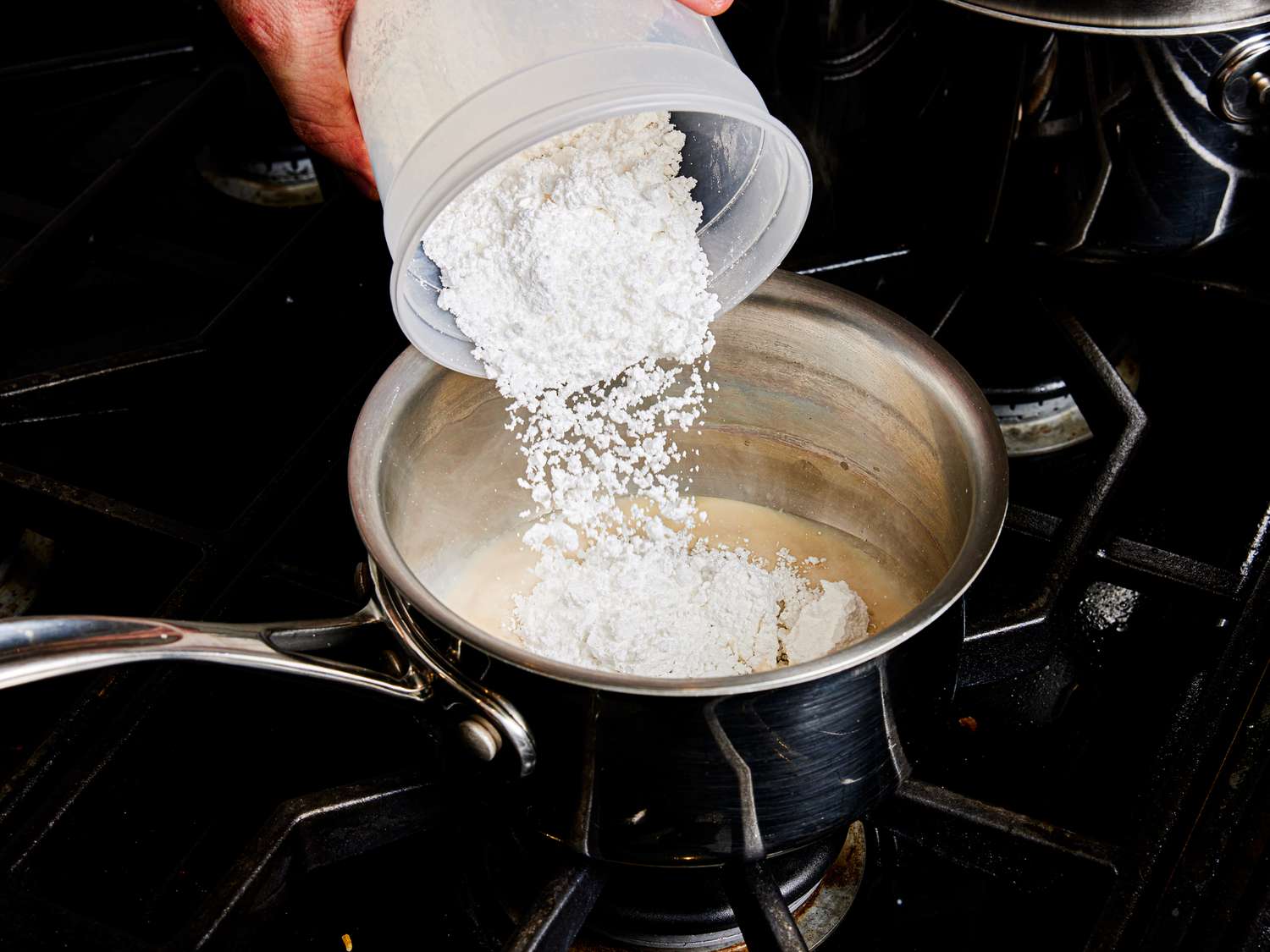 Overhead view of pouring sugar into the pot