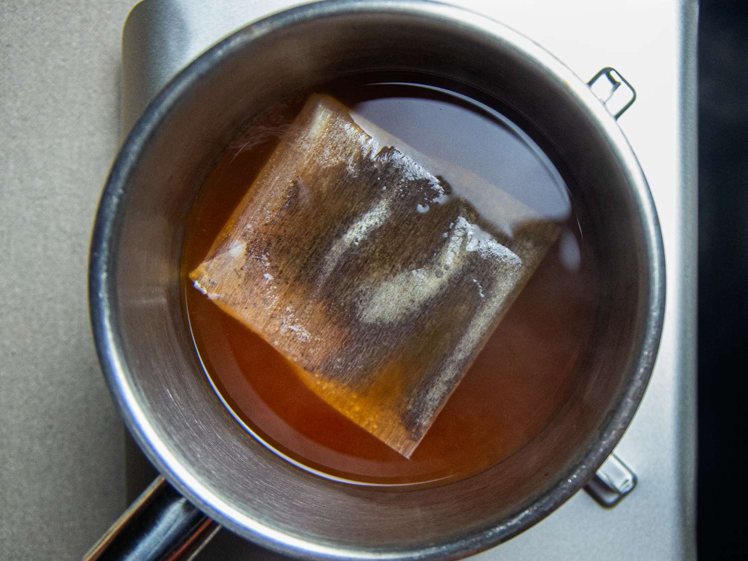 Overhead view of a tea bag boiling