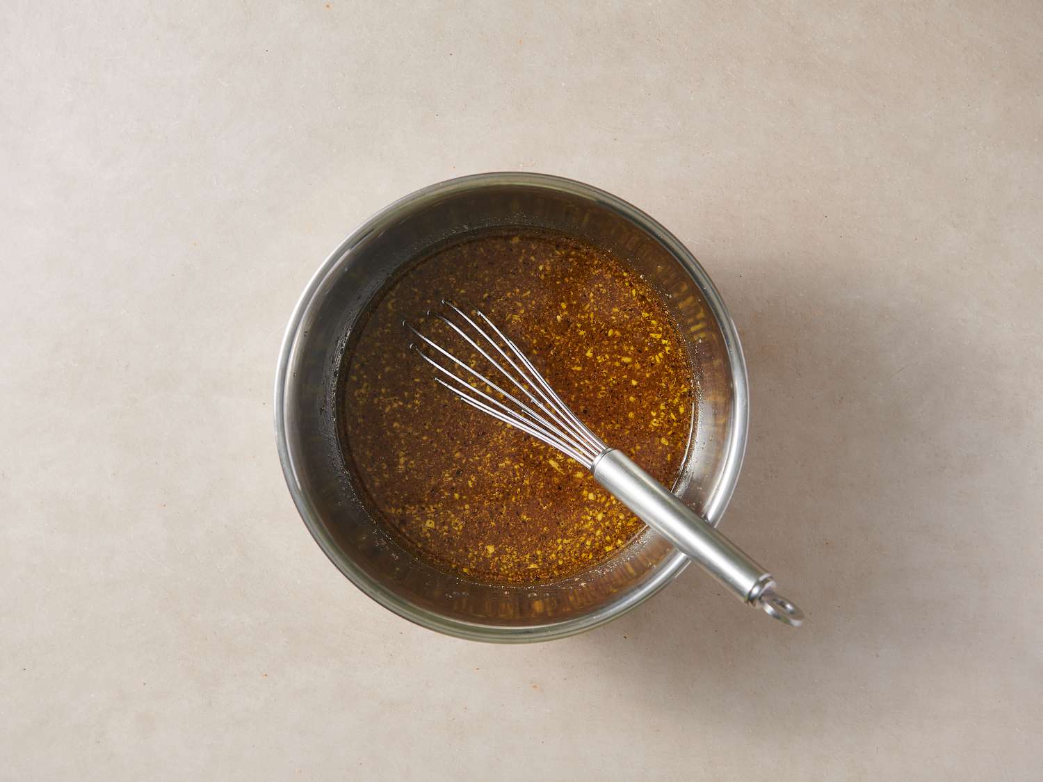 Vinegar, sugar, oil, garlic, black pepper, and celery seeds whisked together in a small bowl