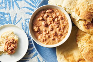 Ful medames served inside a bowl with a side of toasted pita