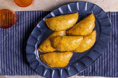 尼日尔ian meat pies on an ovular serving platter.