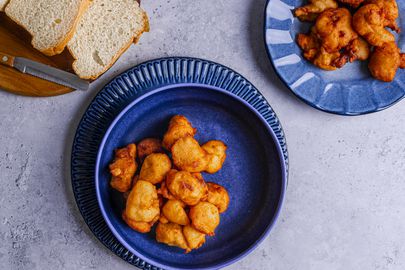 Akara on a deep blue bowl with a serving of white bread and a serving plate