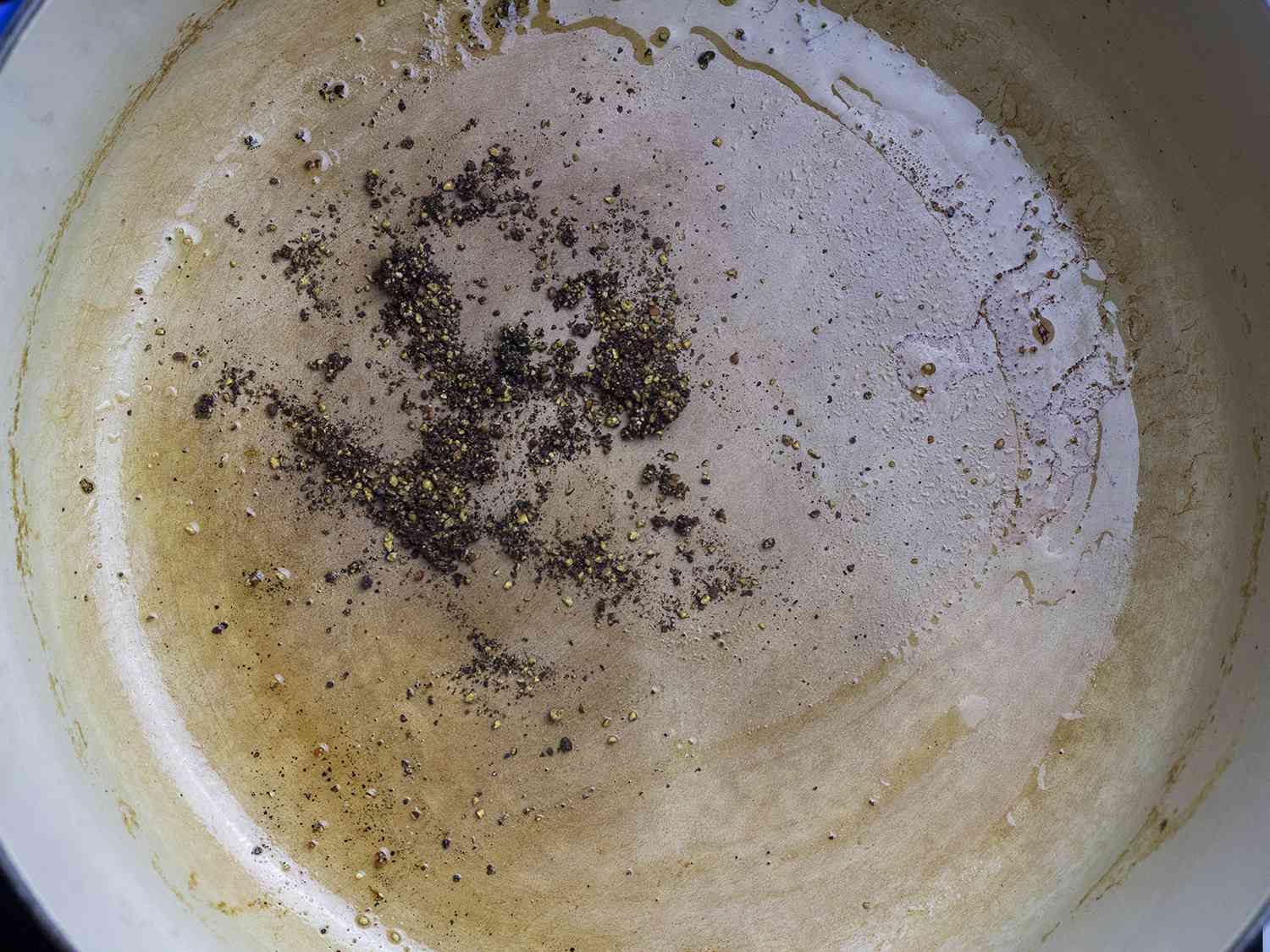 Ground pepper cooking at the bottom of a pot.