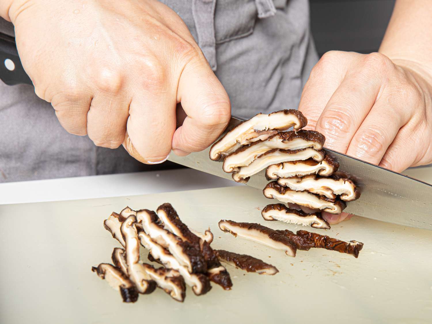 Shiitake mushrooms being sliced.