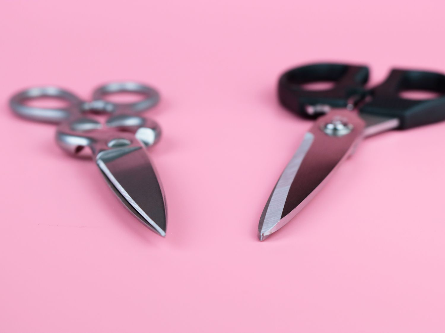 a close up of two different kitchen shears, one with micro-serrations one straight bladed