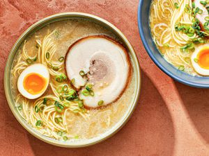 一碗自制的顶部设有一个骨拉面——马rinated egg which has been sliced in half, and a slice of pork chashu.