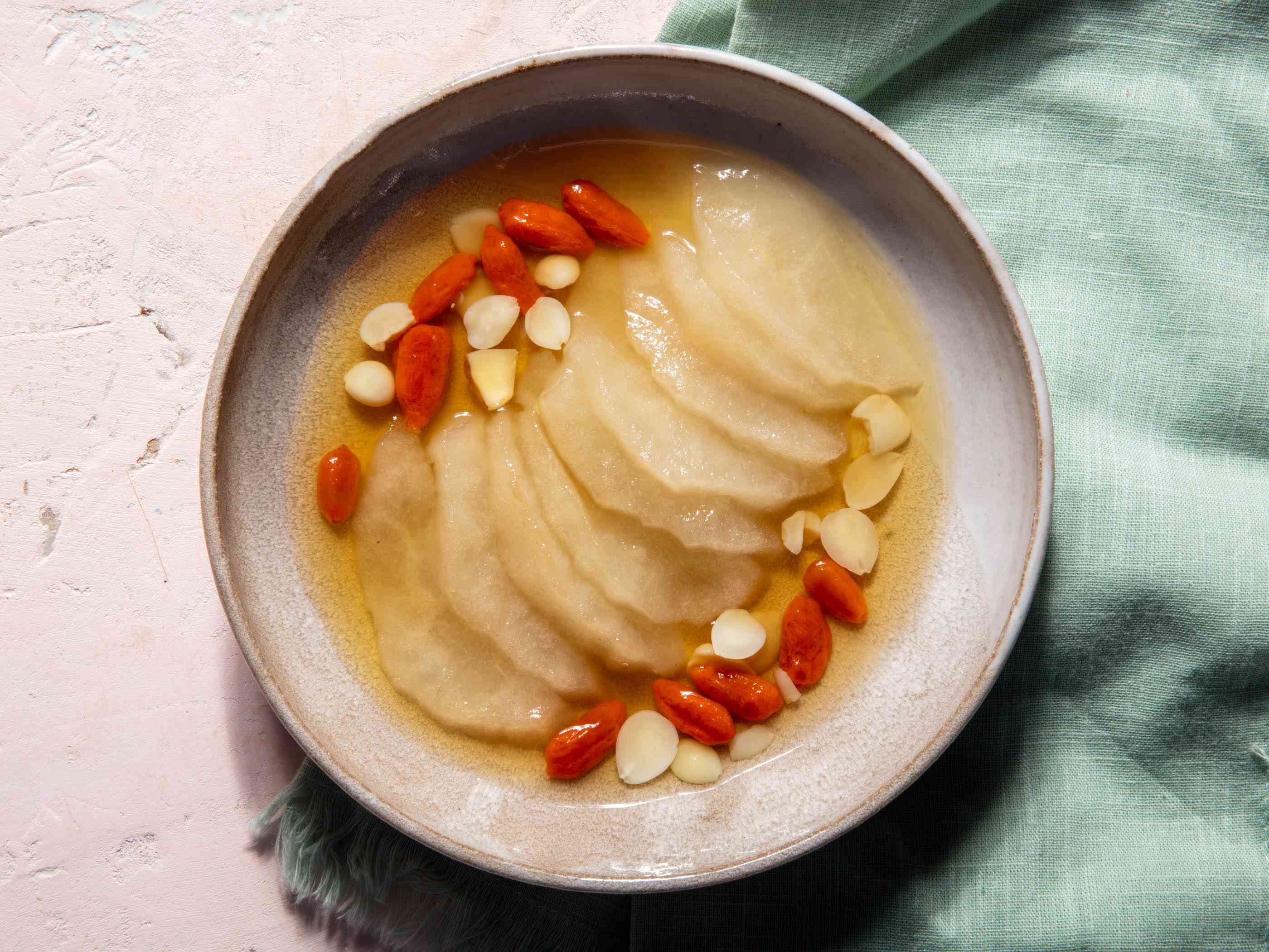 Overhead view of sliced thawed frozen pears with goji berries and Chinese almonds in syrup