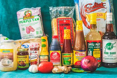 The essential elements of a Filipino pantry arranged in front of a blue backdrop