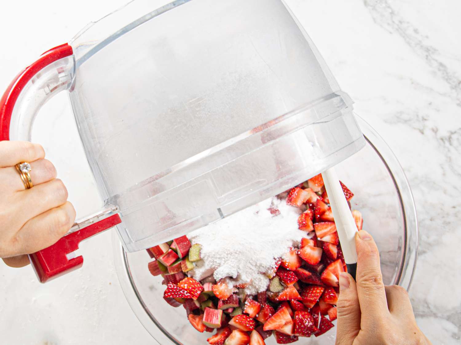 Emptying sugar and tapioca mix into strawberries