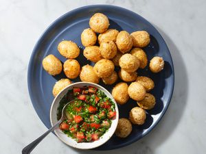 Fried papas criollas on a blue ceramic plate with ajÃ­.