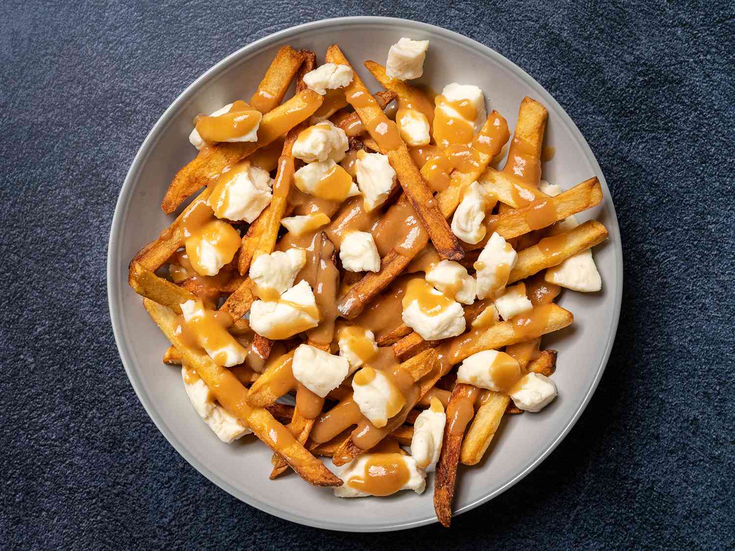 Plate of french fries topped with gravy and cheese curds.