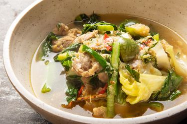 a close up of Gaeng Om Gai (Isan-Style Herbal Curry with Chicken and Dill) in a bowl