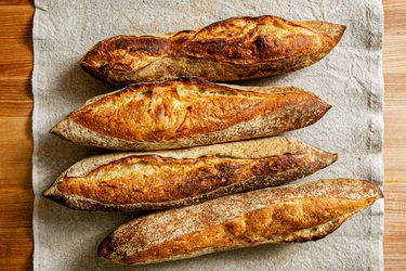 Overhead view of 4 baguettes on a grey table runner