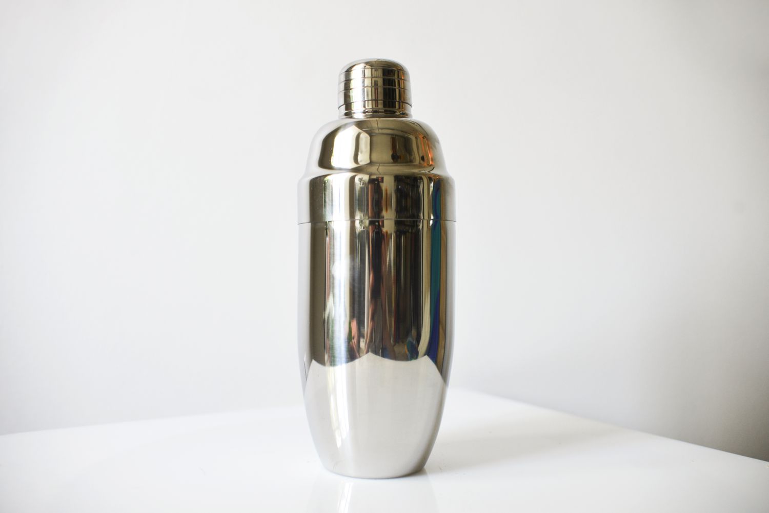 a stainless steel cocktail shaker against a white background