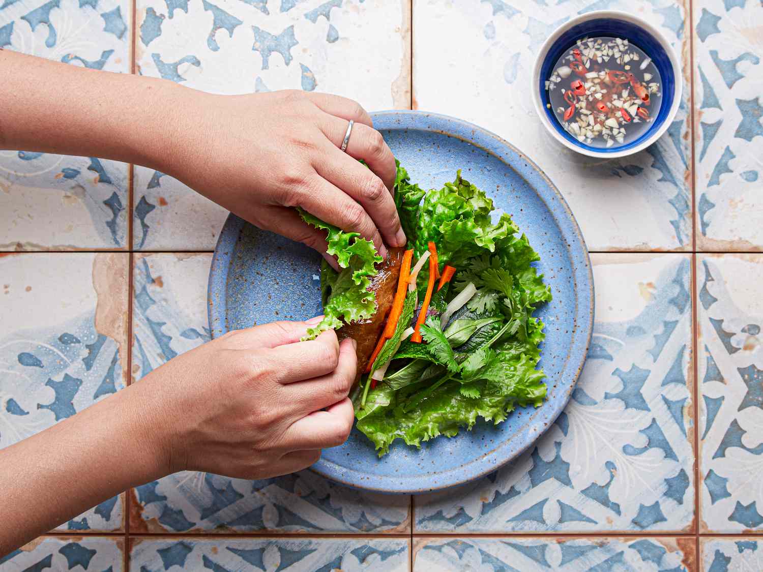 Overhead view of folding an imperial roll in lettuce