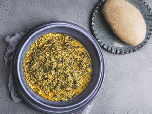 A full bowl of egusi soup served with a serving of eba.