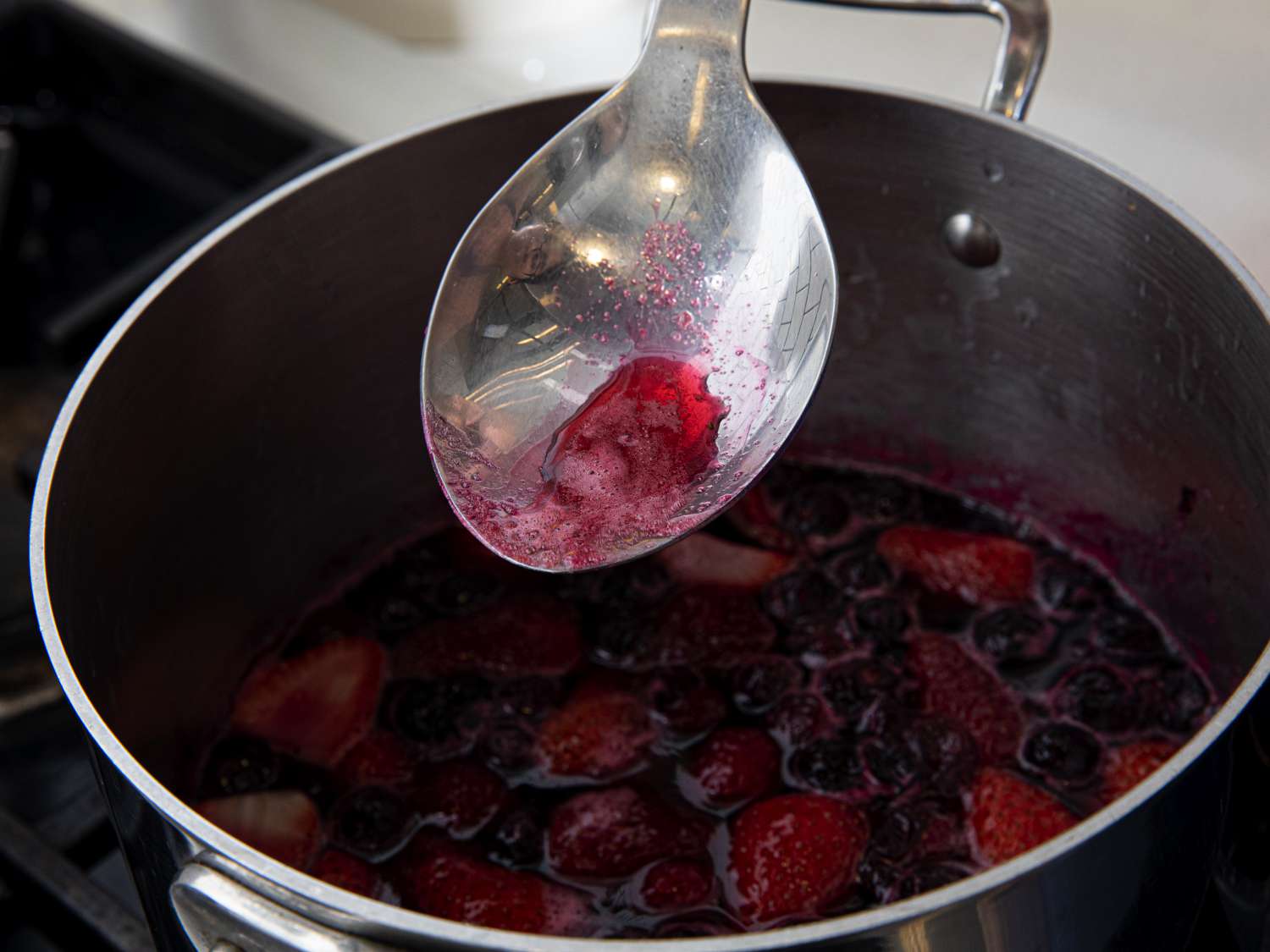 Skimming foam off of cooked berries