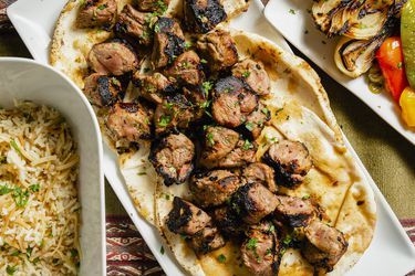 Overhead view of shish kebabs on pita on a plate