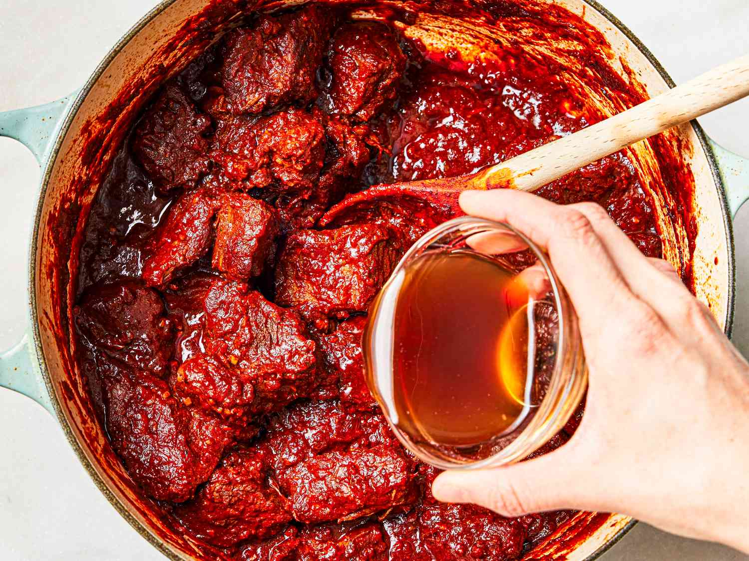 Overhead view of adding fish sauce to beef