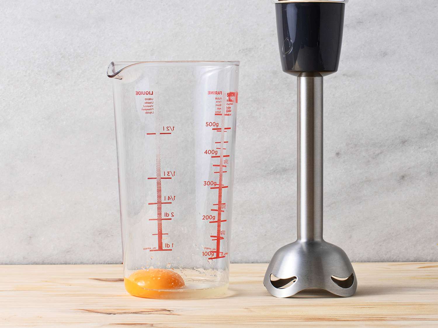 Egg yolk in a measuring cup with an immersion blender