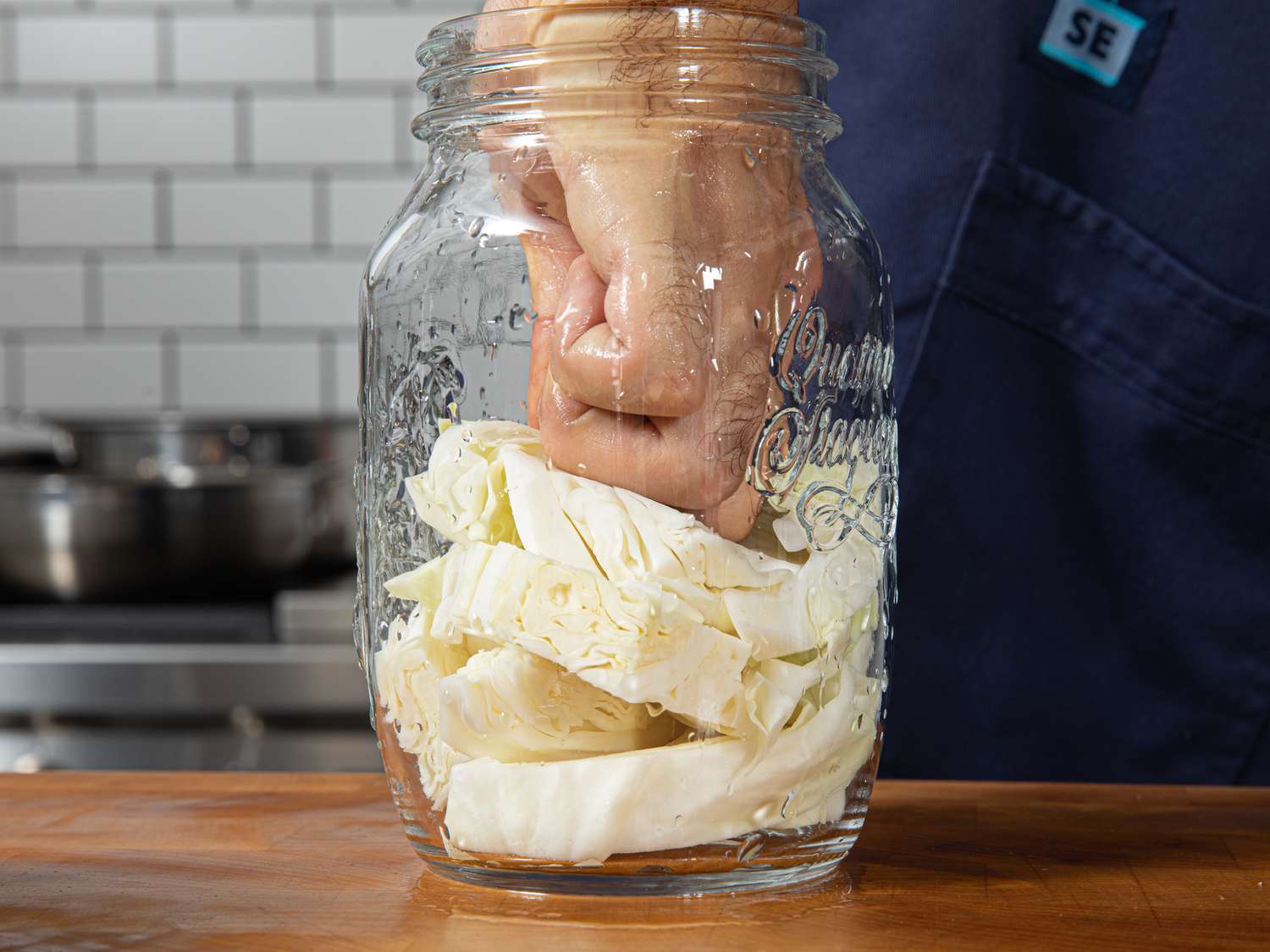 Side view of packing cabbage into a jar