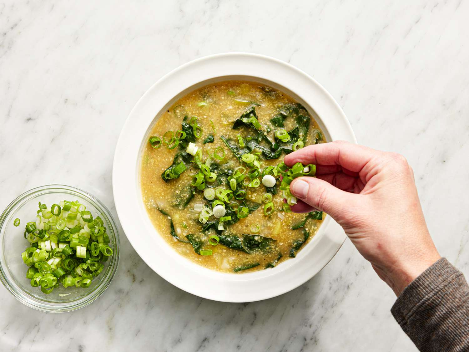 Adding scallions to finished soup