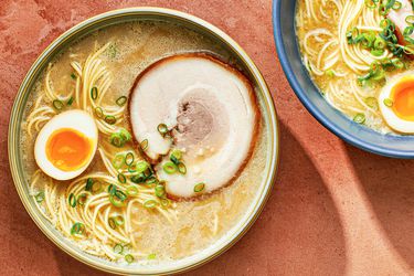 一个bowl of homemade tonkatsu ramen topped with a marinated egg which has been sliced in half, and a slice of pork chashu.