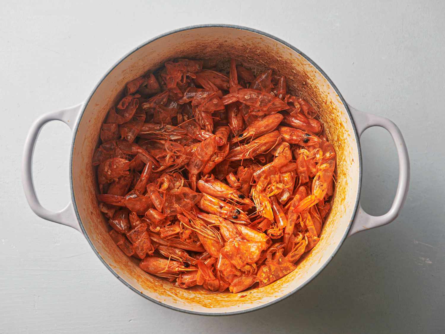 Shrimp and browned bits inside Dutch oven