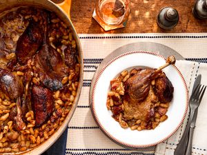 Overhead view of a single single serving of traditional French Cassoulet next to the pot