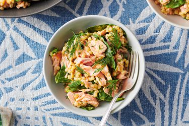 Couscous salad with salmon and mustard-dill dressing served inside a dish and garnished with dill