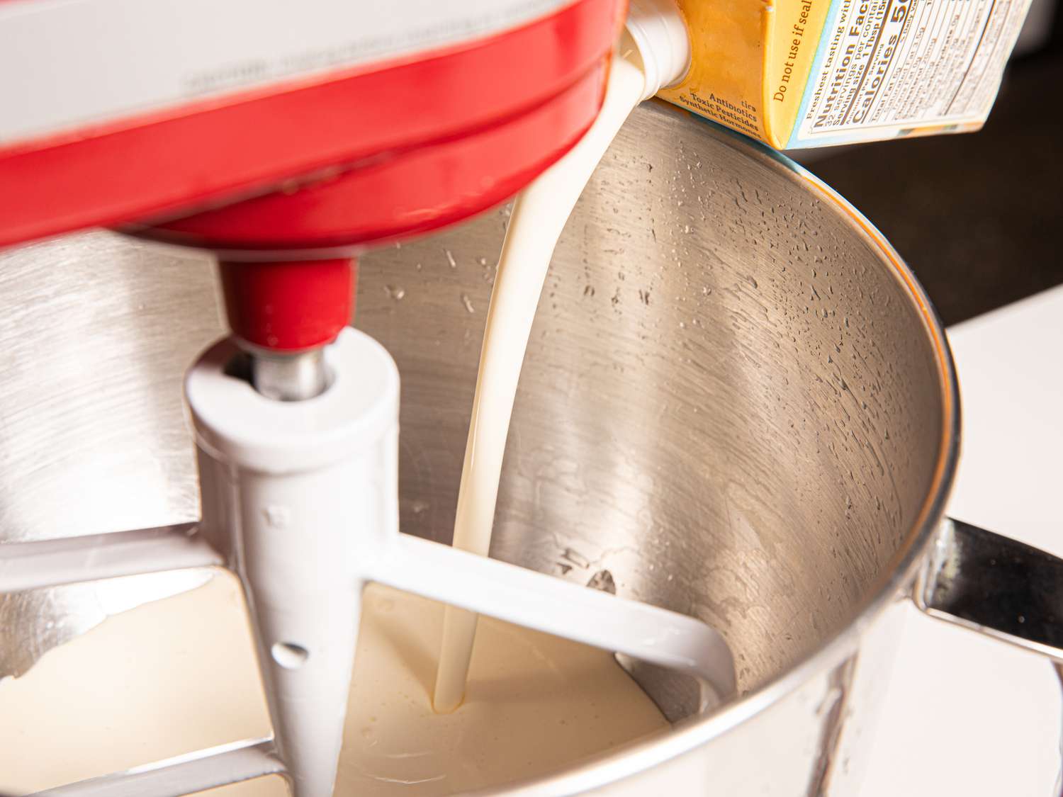 Side view of pouring cream into a standmixer