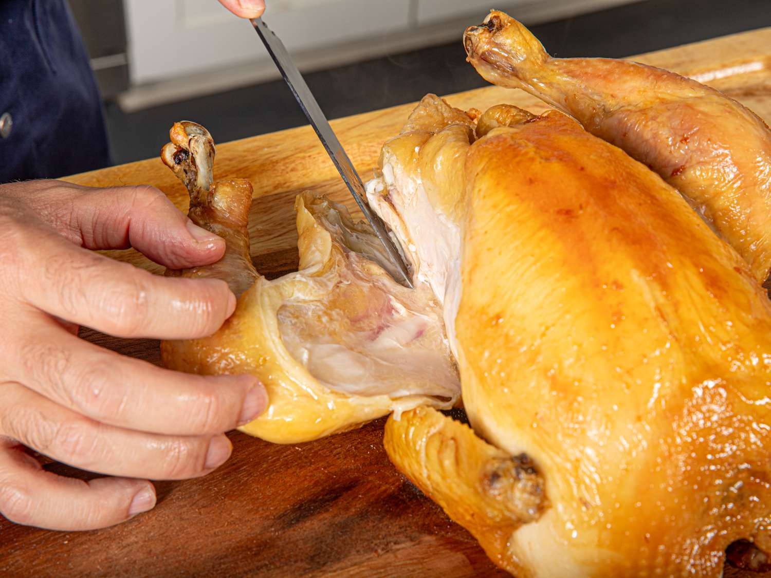 Overhead view of separating the chicken leg from the breast